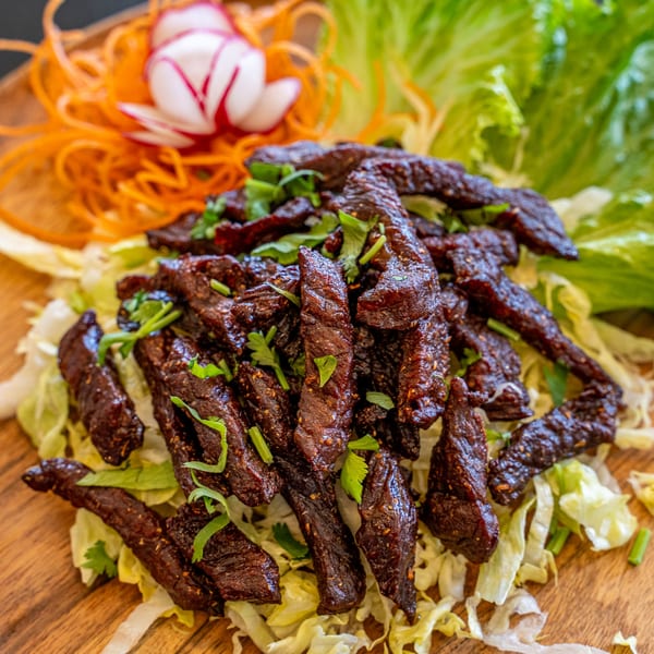 Thai Won On's crispy beef, garnished with cilantro, shredded lettuce, carrots, and a radish flower.